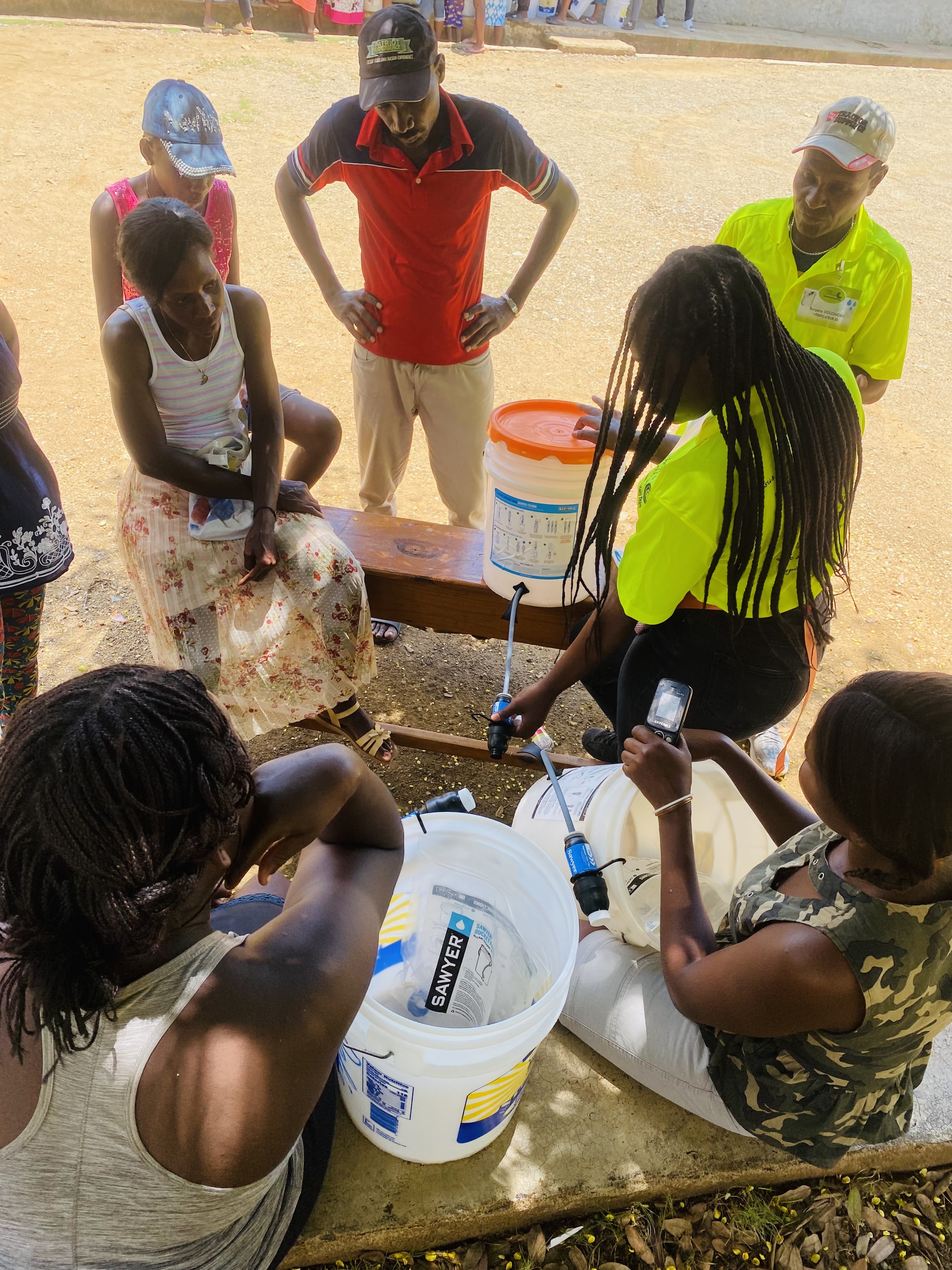 Team members train a group of recipients on how to maintain their filter