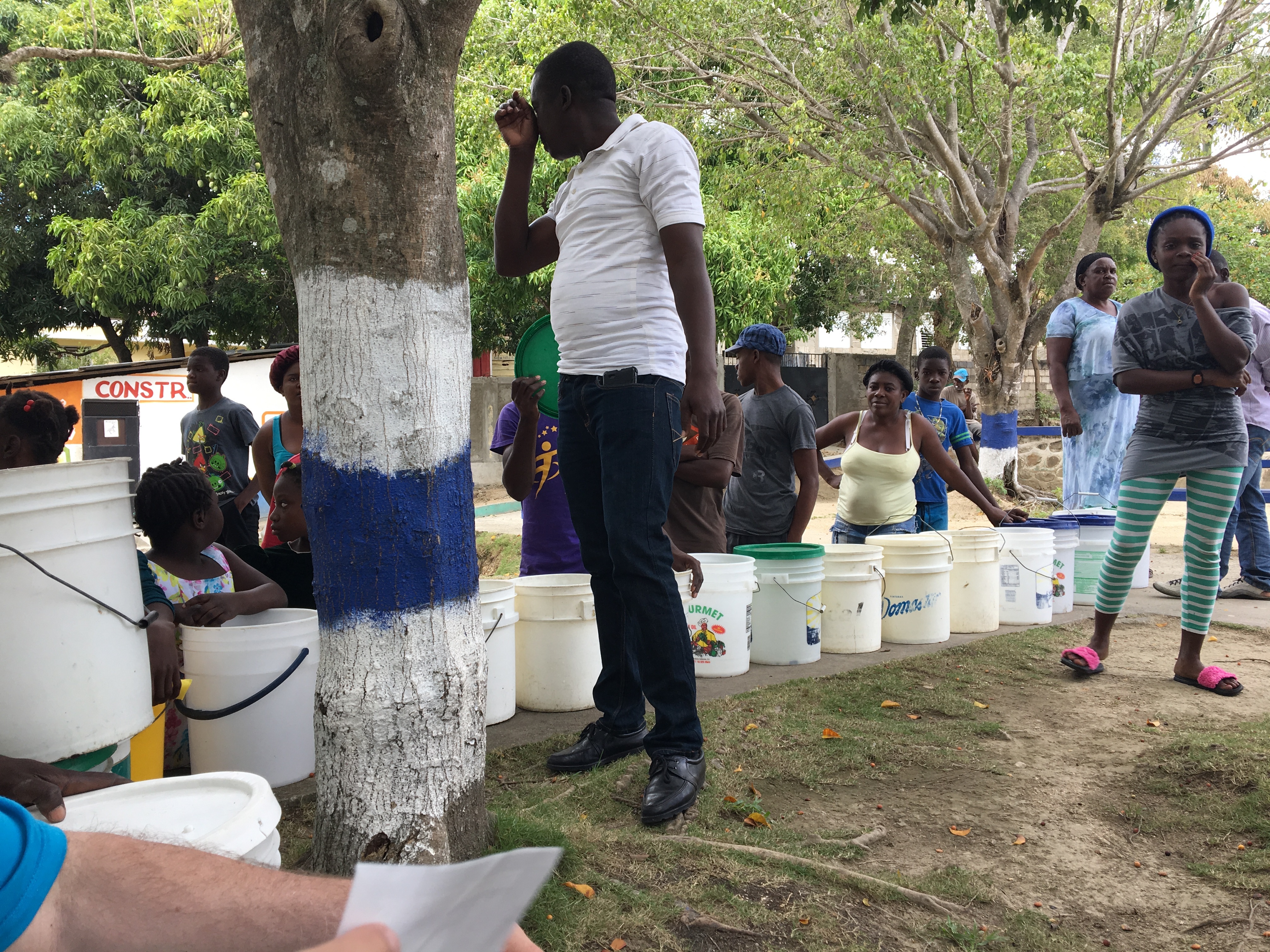 A recipient follows the progress of their bucket as it moves down the wall to get a filter.