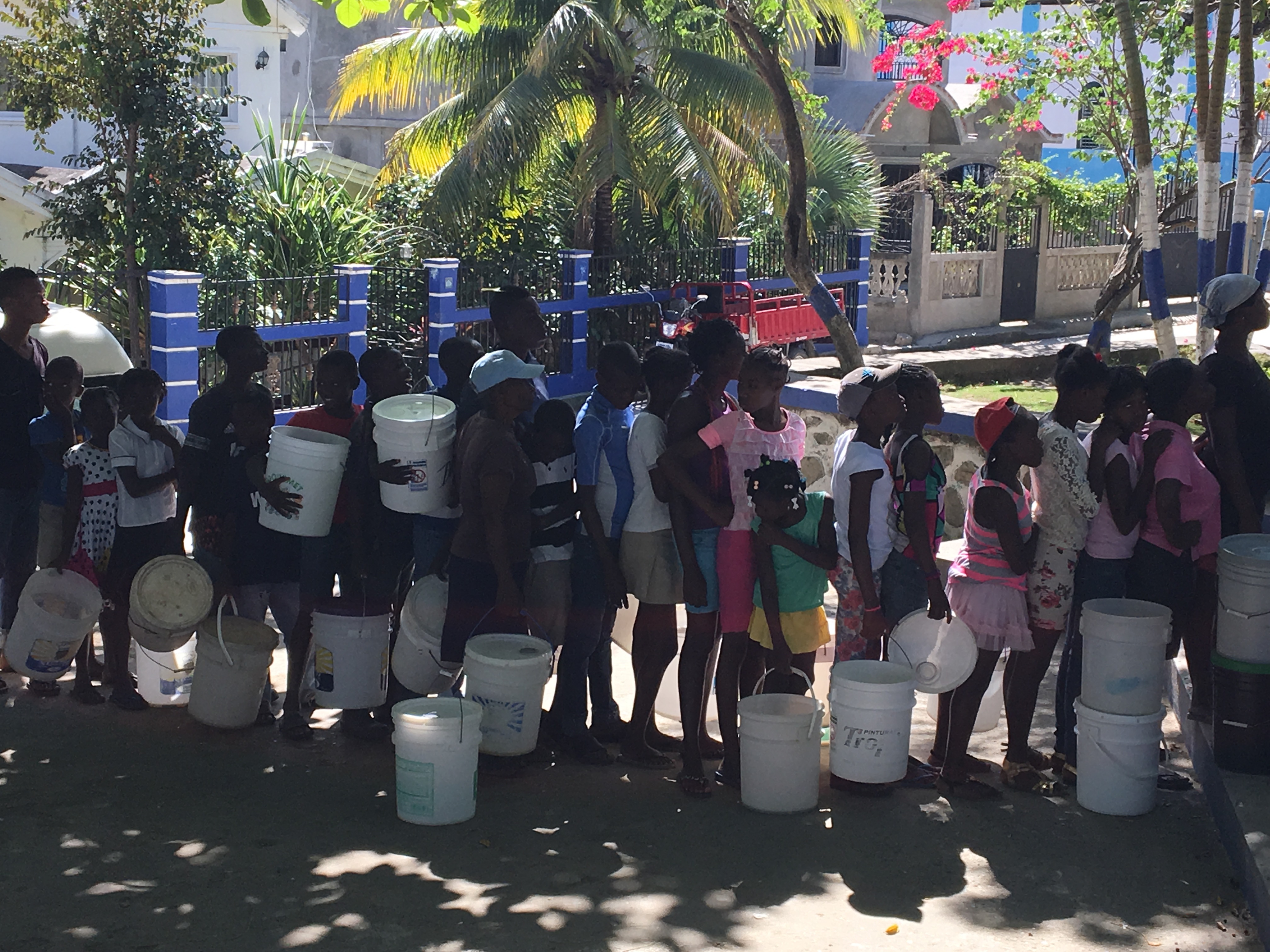 Villagers lined up to get in this picture with their buckets, ready to receive a new clean water filter.