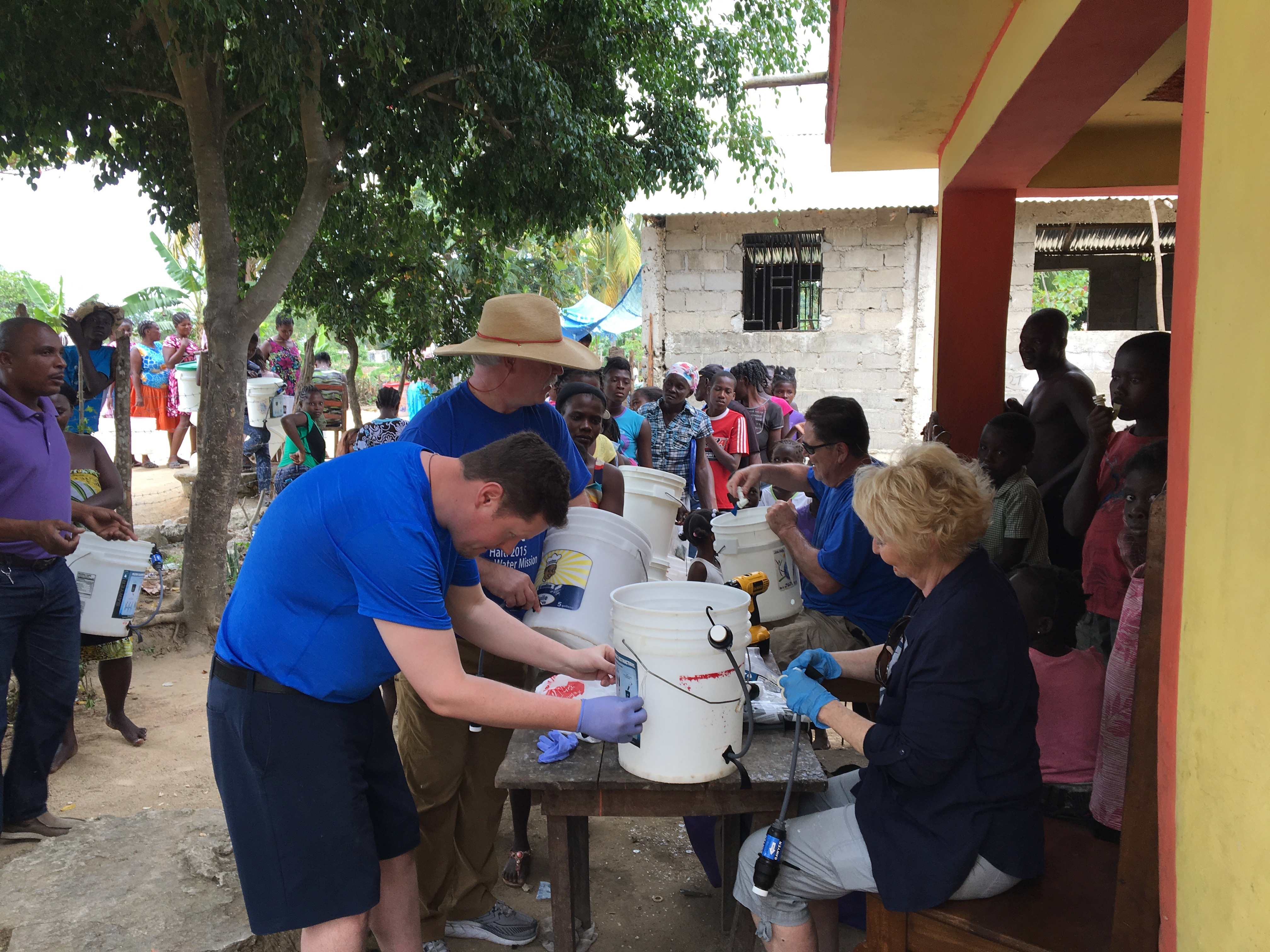 The homeowner brought us out a table to work on, in front of his house. We had quite the audience on the porch as we built bucket systems.